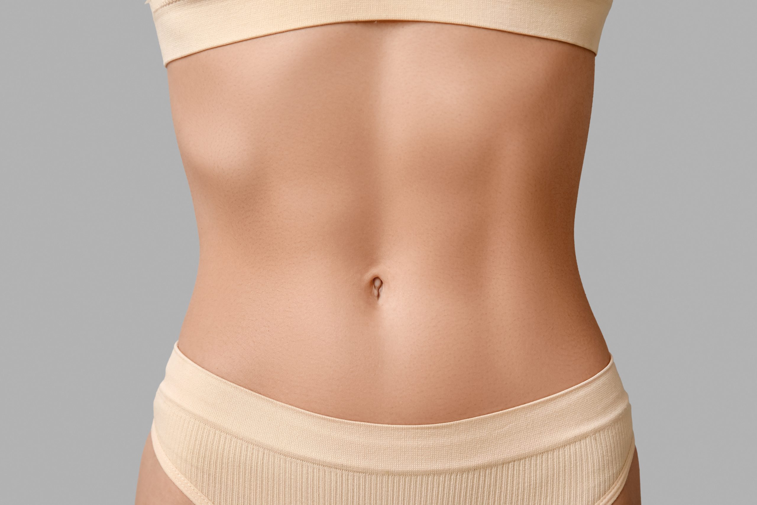 An elegant view of a toned and sculpted body silhouette in a serene clinic environment.
