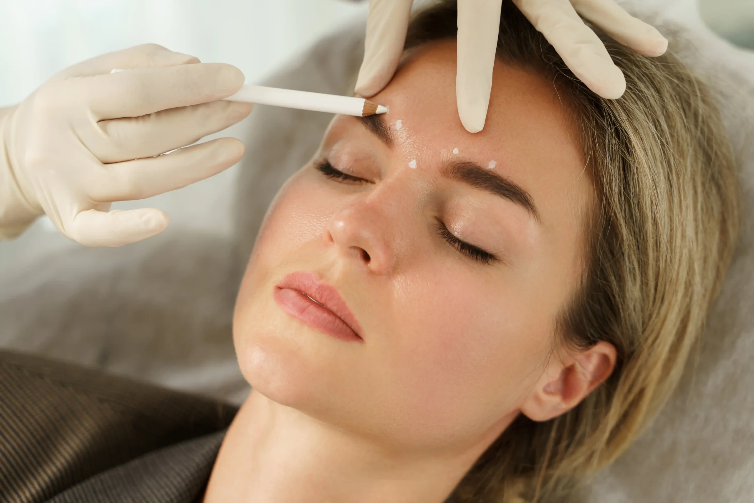 A doctor performing a precise aesthetic treatment on a patient's face.